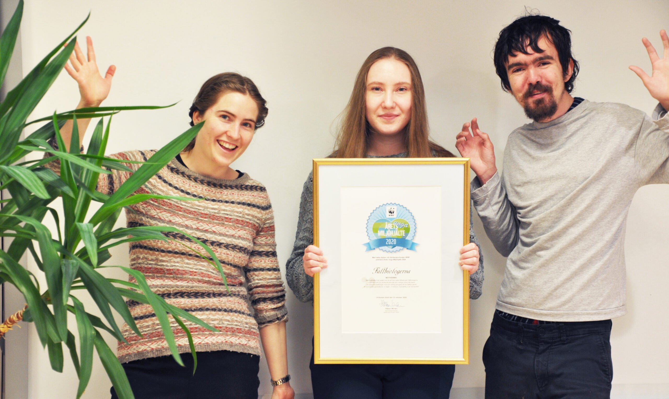 Ordföranden Tove Lönneborg, Lovisa Roos och Leo Rudberg håller upp priset Årets Unga miljöhjälte